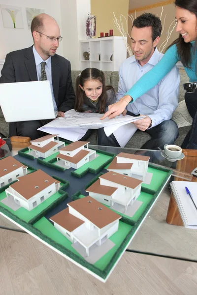 Família discutindo um empreendimento habitacional com um arquiteto — Fotografia de Stock