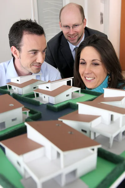 Arquiteto mostrando o modelo de habitação para os clientes — Fotografia de Stock
