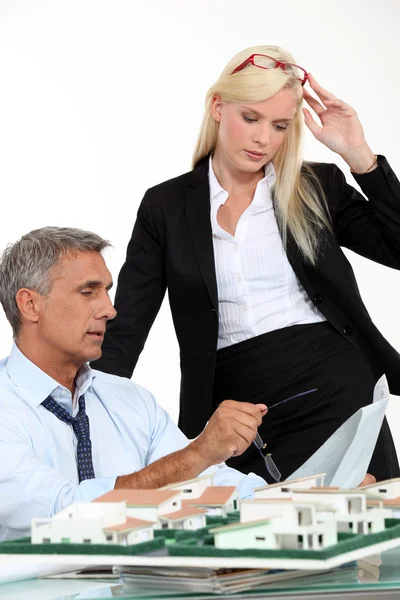 Een baas en zijn vrouwelijke assistent denken achter een Subdivisie model — Stockfoto