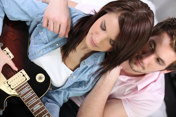 Człowiek szuka dziewczyny gry na gitarze — Zdjęcie stockowe