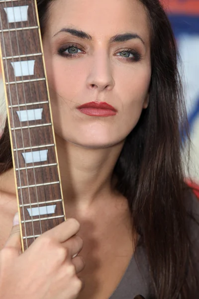 Unfreundliche Frau posiert mit ihrer Gitarre — Stockfoto
