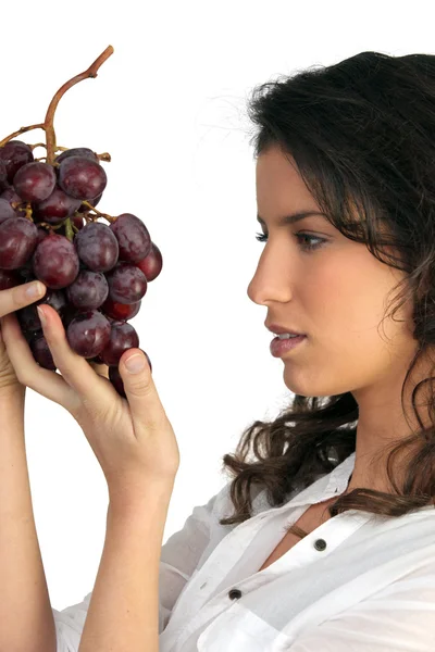 Morena segurando cacho de uvas — Fotografia de Stock