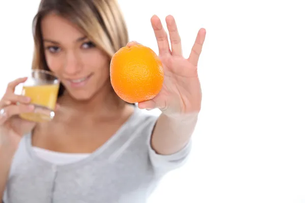 Woman holding orange and orange juice — Stock Photo, Image