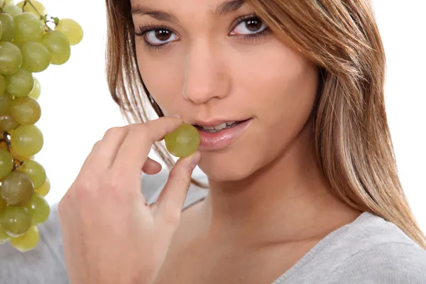 Jovem mulher comendo uvas — Fotografia de Stock