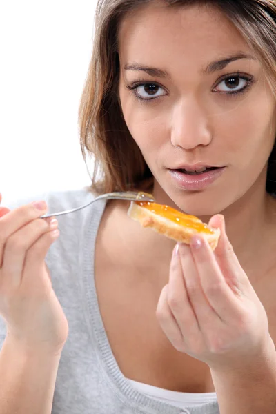Mladá žena jíst přípitek — Stock fotografie