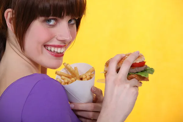 Žena jíst nezdravé jídlo — Stock fotografie