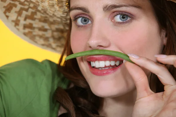 Žena předstírá green bean je knírek — Stock fotografie