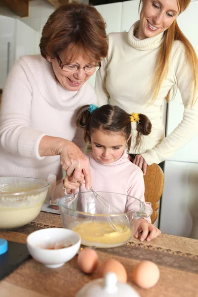 Grandmother making crepes with little granddaughter — Stock Photo, Image