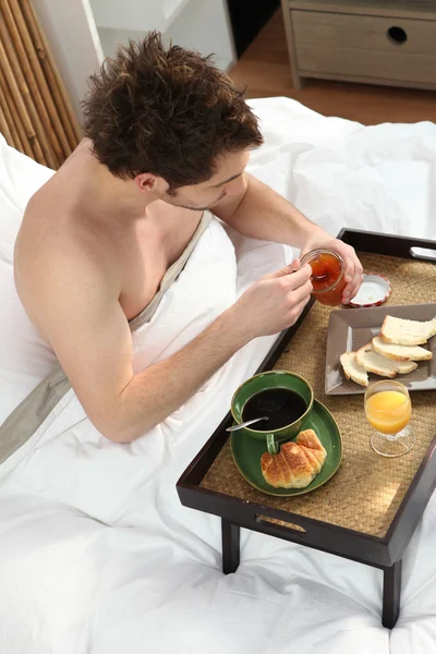 Man äter frukost i sängen ensam — Stockfoto