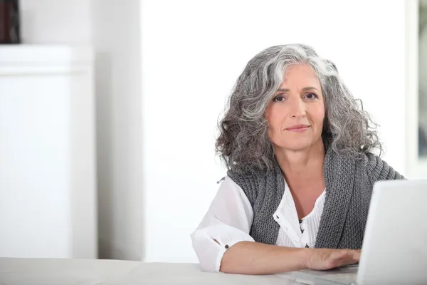 Vrouw met grijze haren en computer — Stockfoto