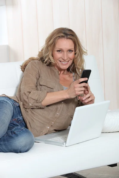 Blondine mit Telefon und Computer — Stockfoto