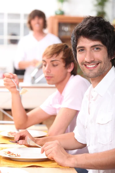 Young men eating a meal — Stock Photo, Image