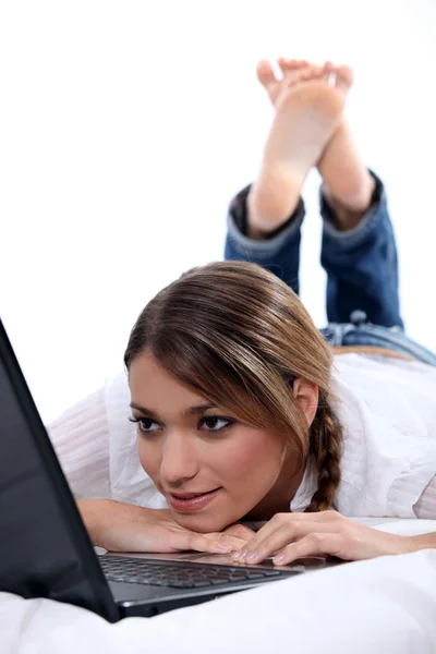 컴퓨터와 함께 거짓말 하는 여자 — 스톡 사진