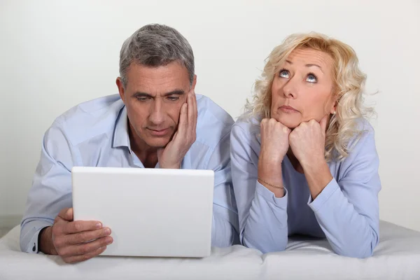 Мужчина и жена скучают с компьютером — стоковое фото