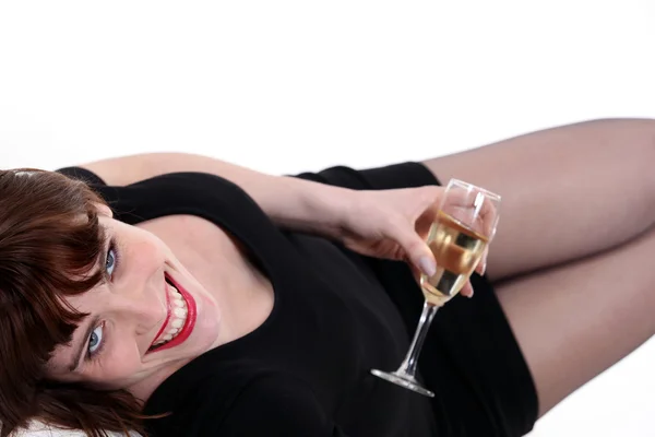 Bir kadeh şampanya ile yatarken kadın — Stok fotoğraf
