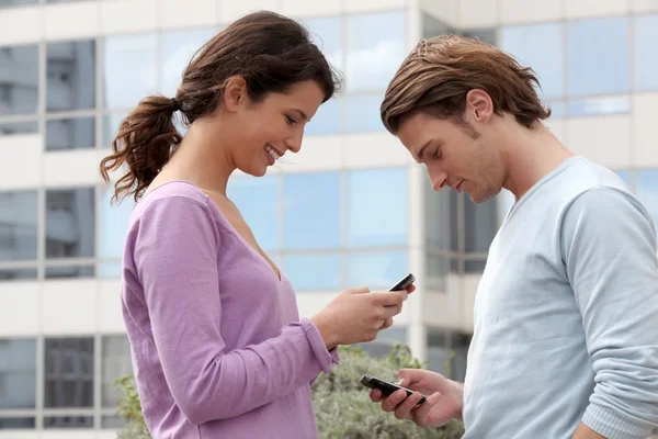 Couple envoyant des SMS à l'extérieur — Photo