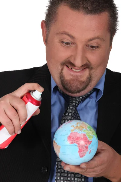 Portret van een zakenman spuiten een globe — Stockfoto