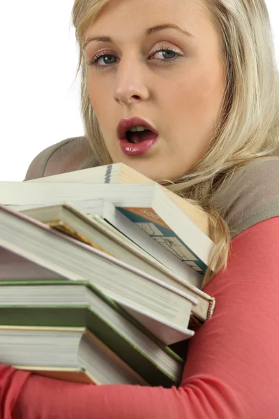 Молодая женщина переутомилась со стопкой книг — стоковое фото