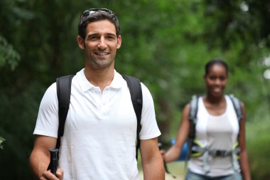 Couple with backpacks in the forest clipart