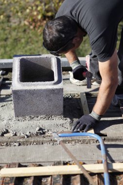 Man adjusting cinder block placement clipart