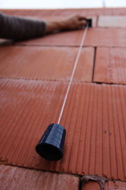 Bricklayer using a plumb line clipart