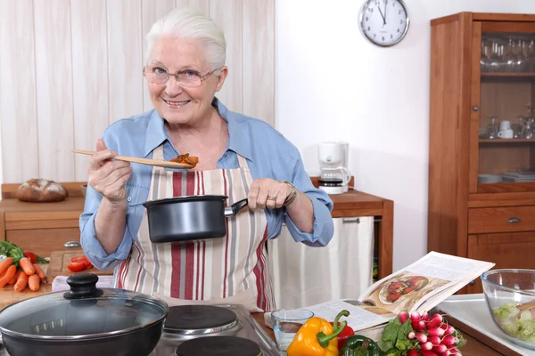 Idősebb nő főzés, étkezés — Stock Fotó