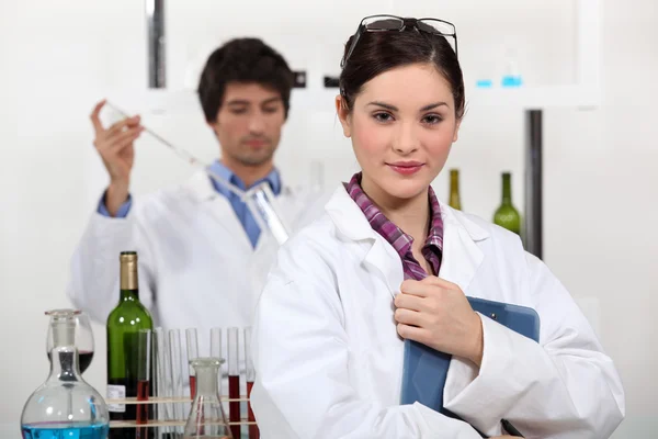 Hombre y mujer probando vino en laboratorio — Foto de Stock