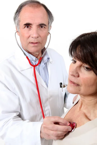 Läkare som lyssnar på en kvinnas bröst — Stockfoto