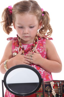 Young girl playing with mommy's jewelry clipart