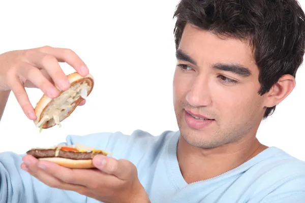Adam bir hamburger açma — Stok fotoğraf