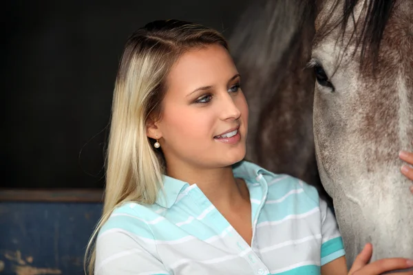 En ung kvinna smeka en häst — Stockfoto