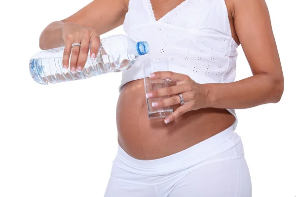 Беременная женщина наполняет стакан воды — стоковое фото