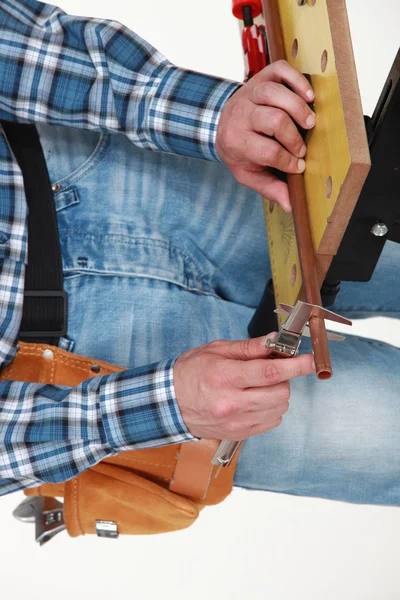 Male hands calibrating copper tube — Stock Photo, Image