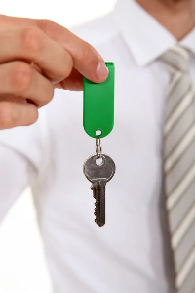 Агент по недвижимости держит ключ от дома — стоковое фото