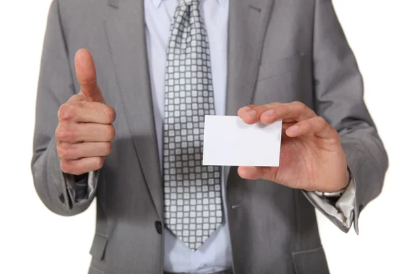 Businessman giving the thumbs up as her displays business card — Stock Photo, Image