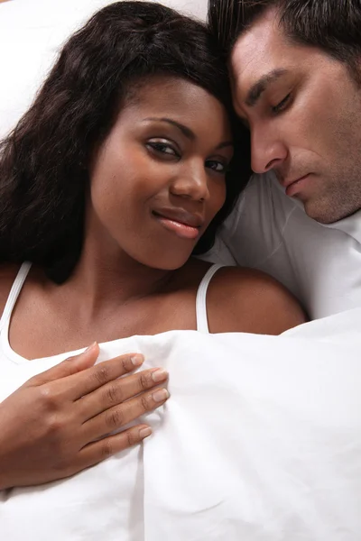 Mixed couple laying in bed — Stock Photo, Image