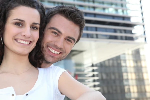 Couple in front of modern building — Stock Photo, Image