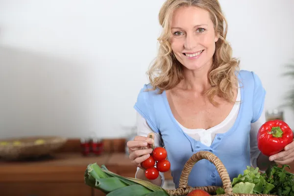 Vrouw bedrijf peper en tomaten — Stockfoto