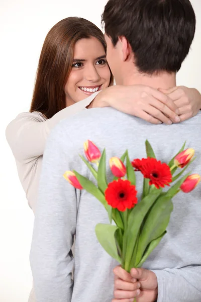 Hombre sorprendiendo a su novia con un ramo de flores — Foto de Stock