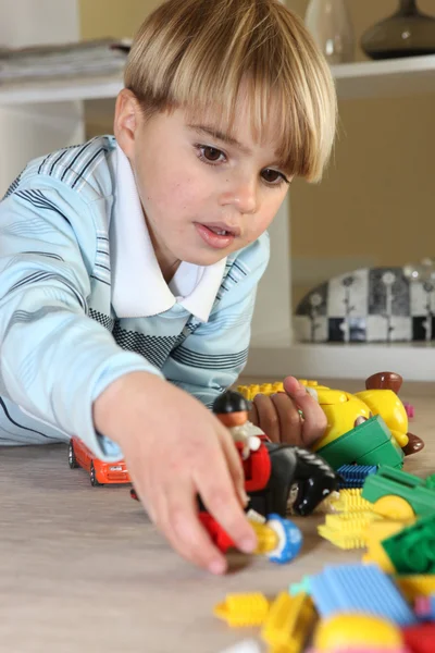 Liten blond pojke leker med leksaker — Stockfoto