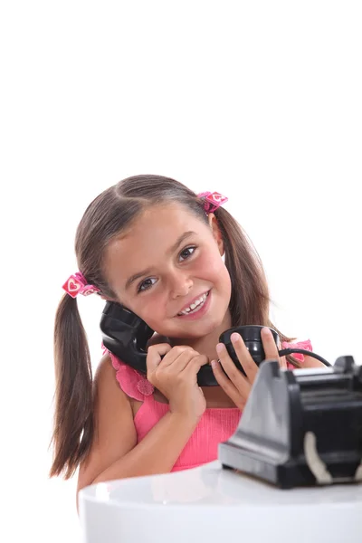 Молода дівчина використовує старий чорний телефон — стокове фото