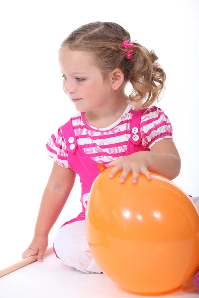 Liten flicka spelar med ballong — Stockfoto