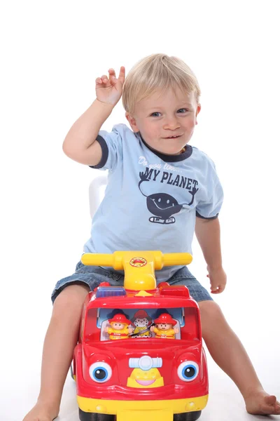 Menino sentado em veículo de brinquedo — Fotografia de Stock