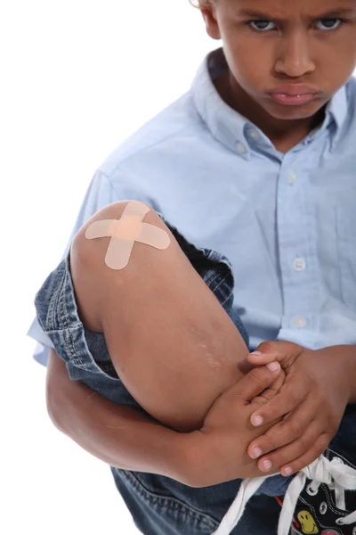 Pojke med ett gips på sitt knä — Stockfoto