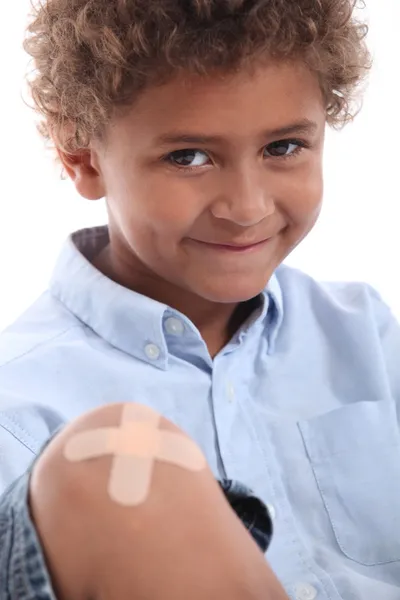 Cute boy with a plaster on his knee — Stock Photo, Image