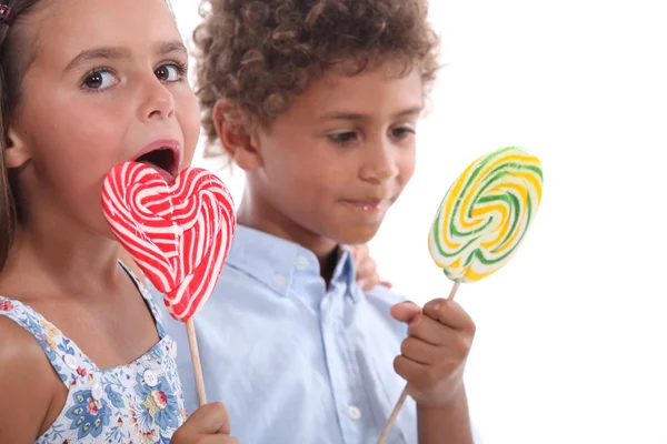 两个孩子吃棒棒糖的特写 — 图库照片