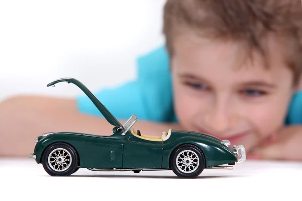 Μικρό αγόρι βλέποντας ένα αυτοκίνητο παιχνίδι — Φωτογραφία Αρχείου