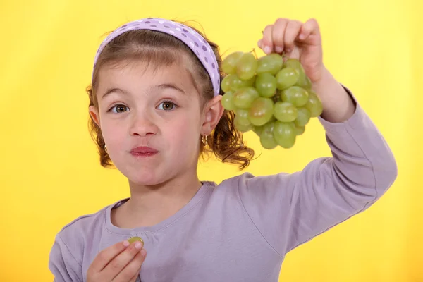 Маленькая девочка держит кучу зеленого винограда — стоковое фото