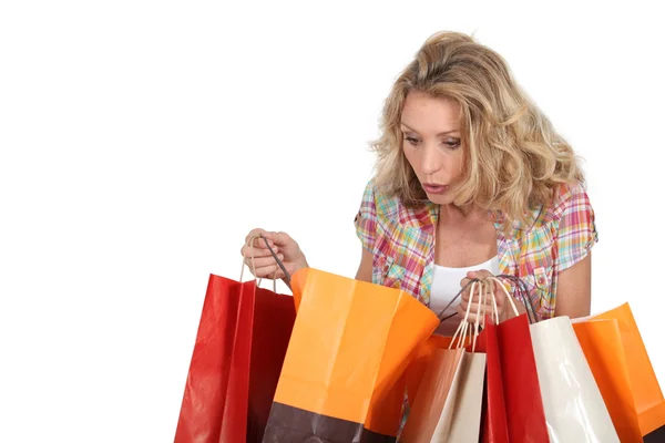 Kobieta patrząc w torby na zakupy — Zdjęcie stockowe