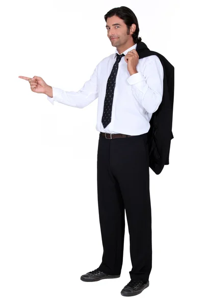 Man with a suit jacket flung over his shoulder pointing at a screen — Stock Photo, Image
